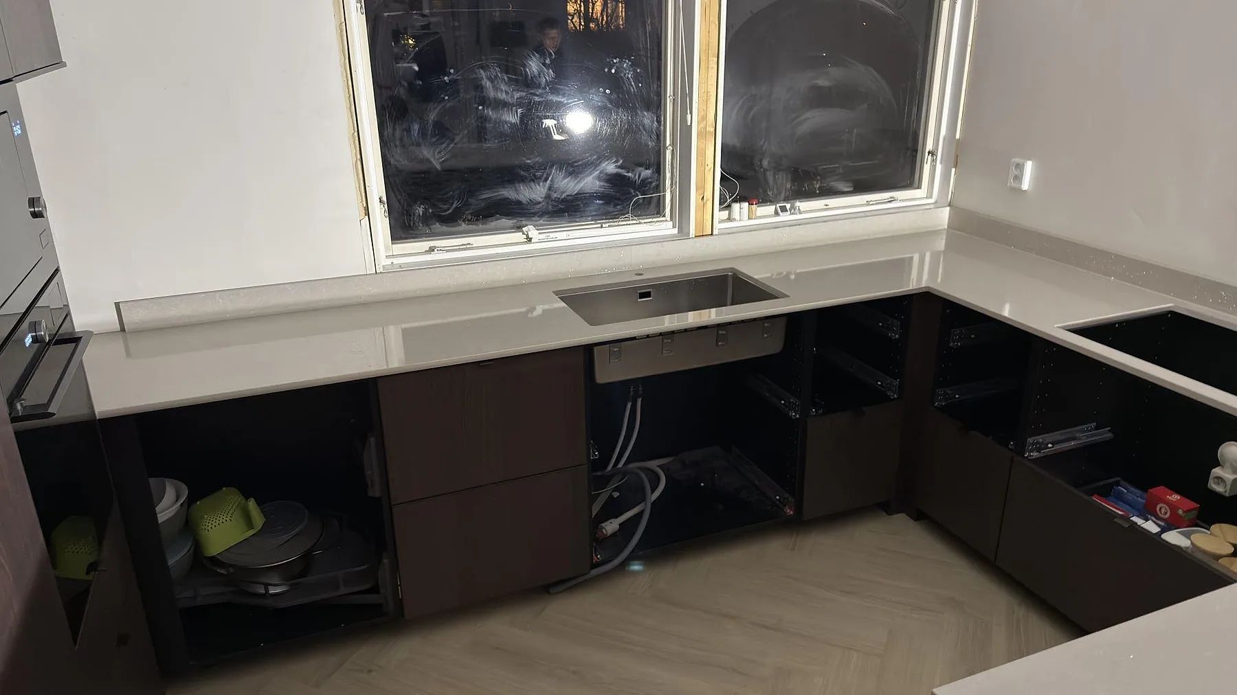Underlimmad rostfri diskho i en köksbänkskiva av Technistone Noble Ivory White under fönsterväggen i ett kök i Västerhaninge.