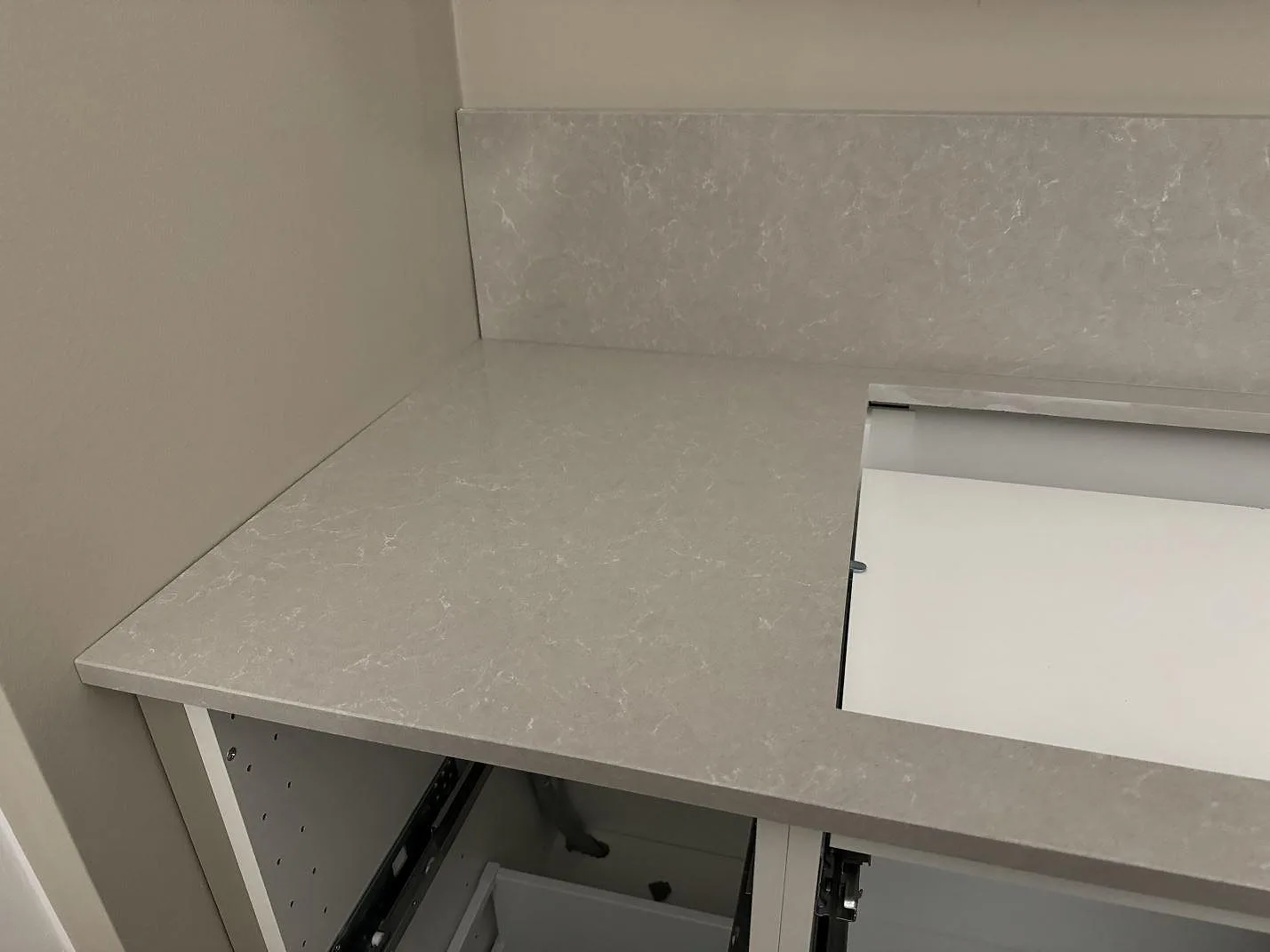 Installerad bänkskiva i Technistone Noble Ivory White, polerad komposit, med uppvikt stänkkant och hälluttag i Vellinge.