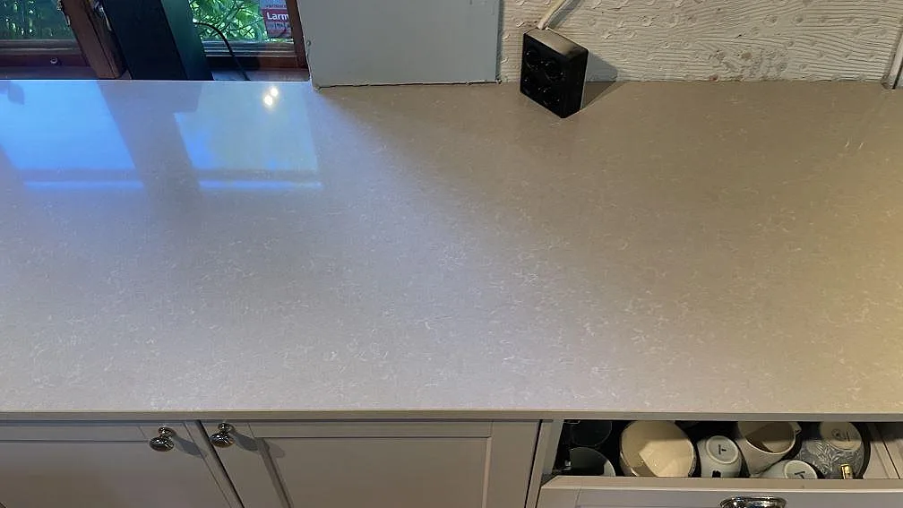 Fönsternära köksbänkskiva i polerad Technistone Noble Ivory White, komposit, med ljus ådring i Vellinge.