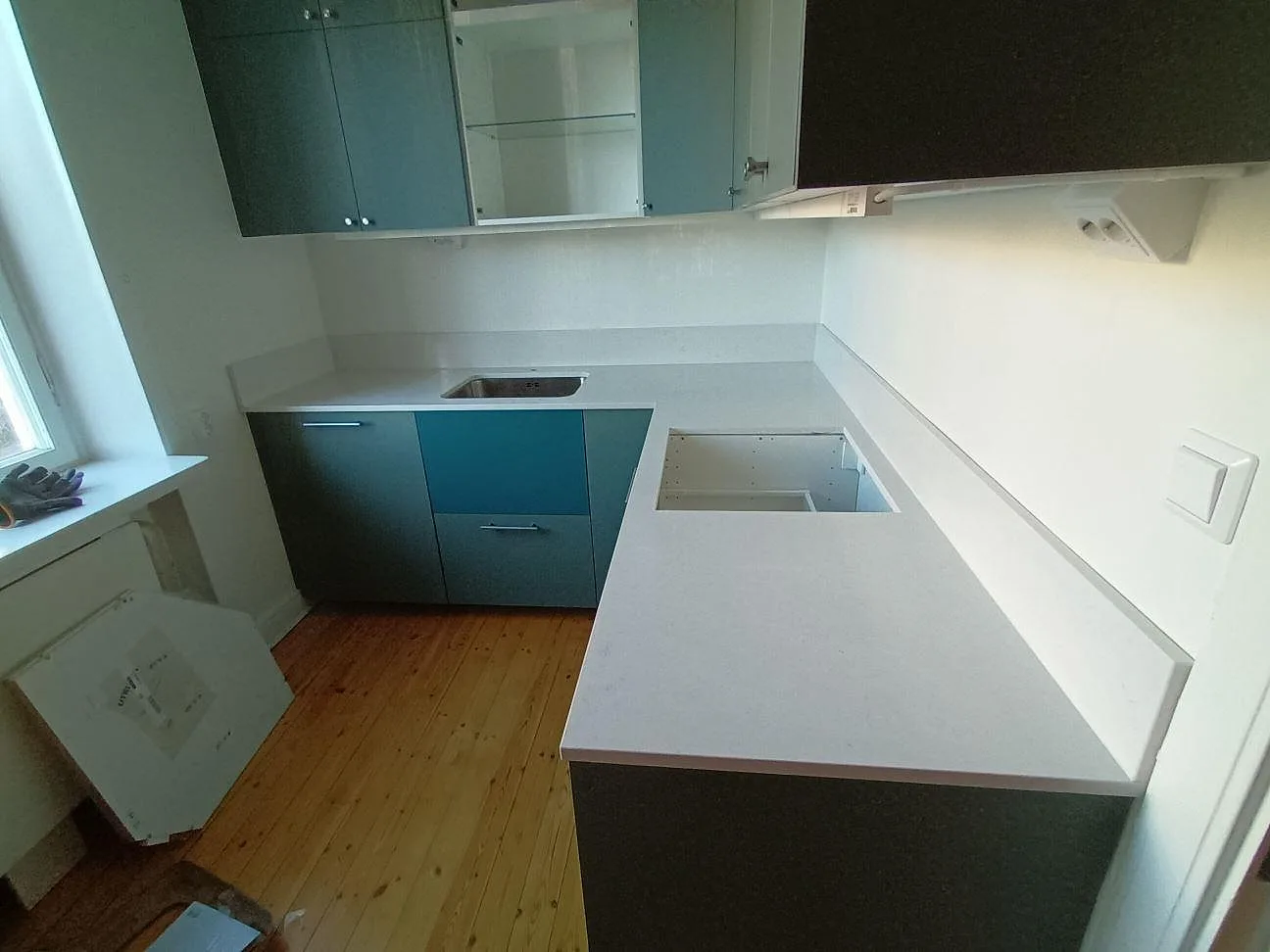 U-formad köksbänkskiva i Technistone Noble Linea, 20 mm polerad komposit, med uppvikt stänkkant i ett kök i Uppsala.
