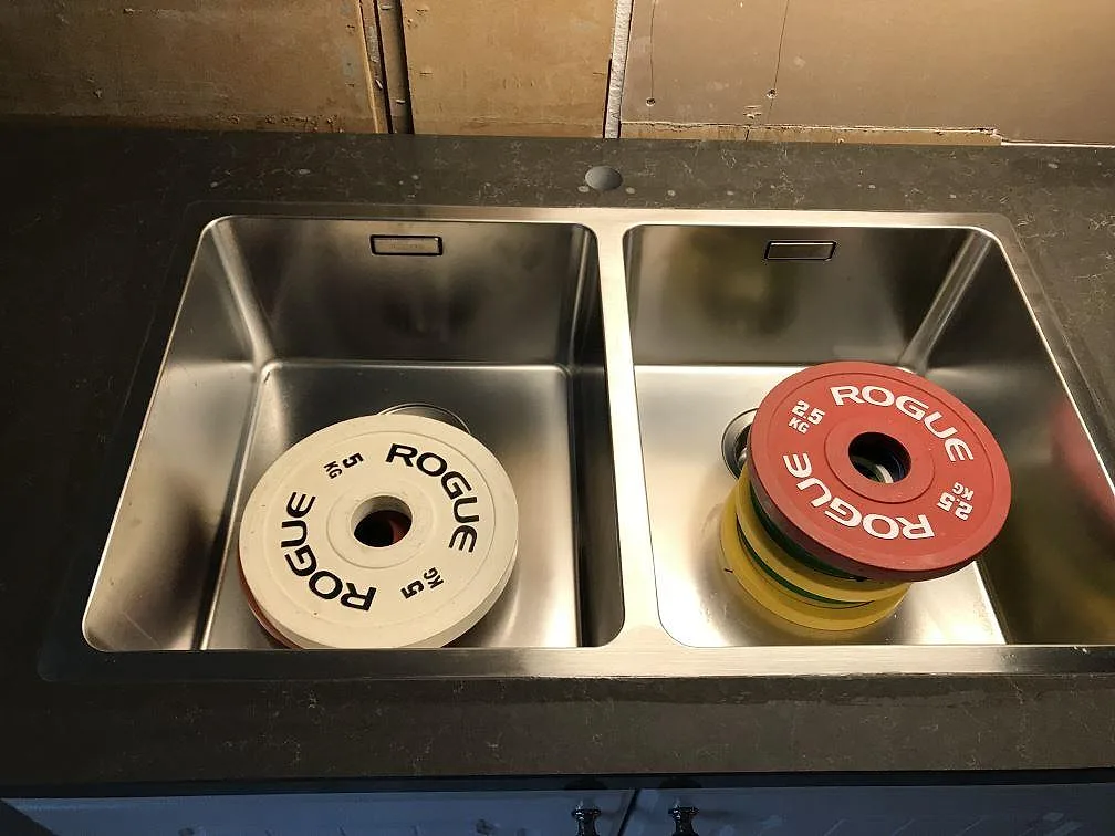 Två underlimmade rostfria diskhoar i en köksbänkskiva av Technistone Noble Pietra Grey i ett kök i Fjärås.