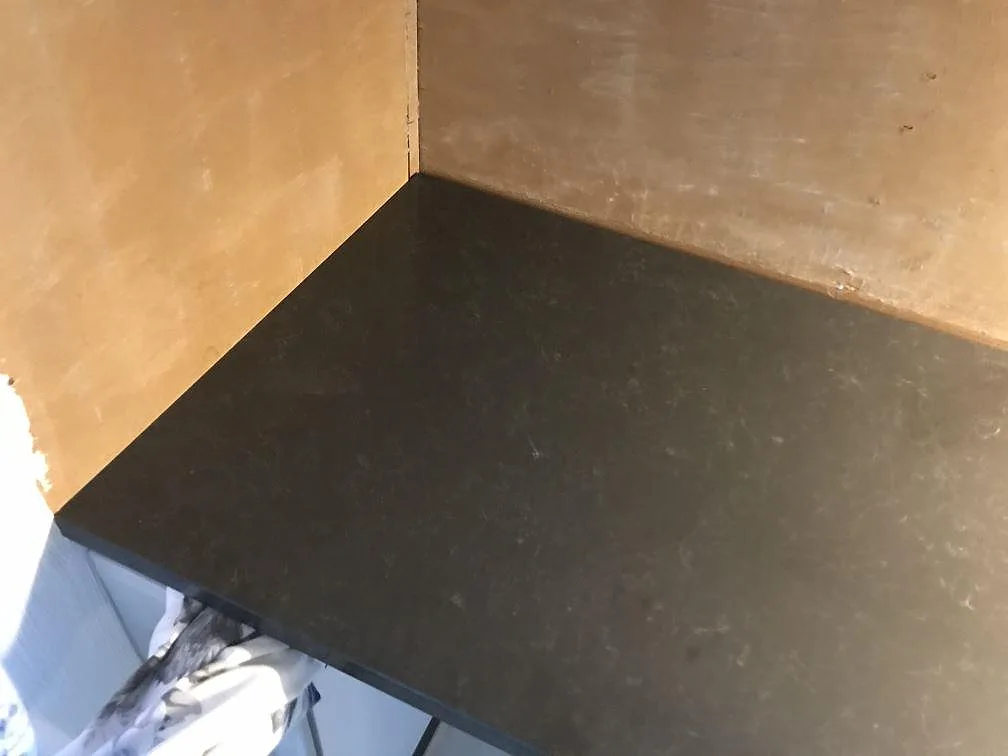 Närbild på den polerade ytan och kanten av en bänkskiva i Technistone Noble Pietra Grey kvartskomposit i ett kök i Fjärås.