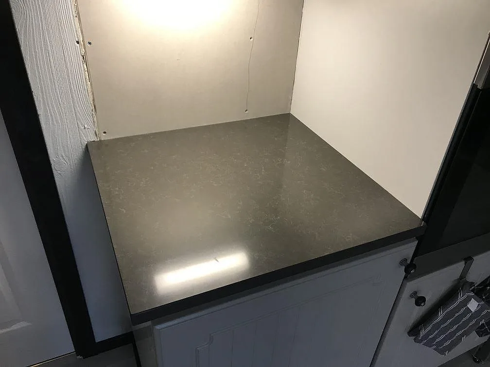 Polerad bänkskiva i Technistone Noble Pietra Grey i ett köksparti med grå luckor i Fjärås.