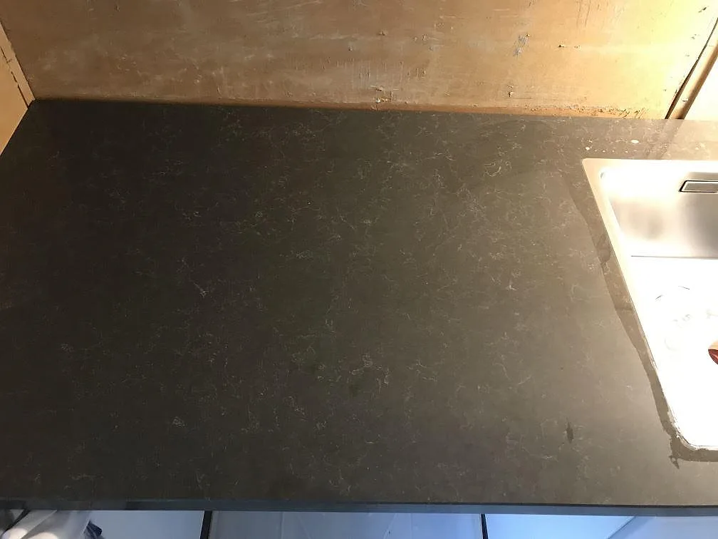 Köksbänkskiva i Technistone Noble Pietra Grey med underlimmad rostfri diskho, fotograferad under montering i ett kök i Fjärås.