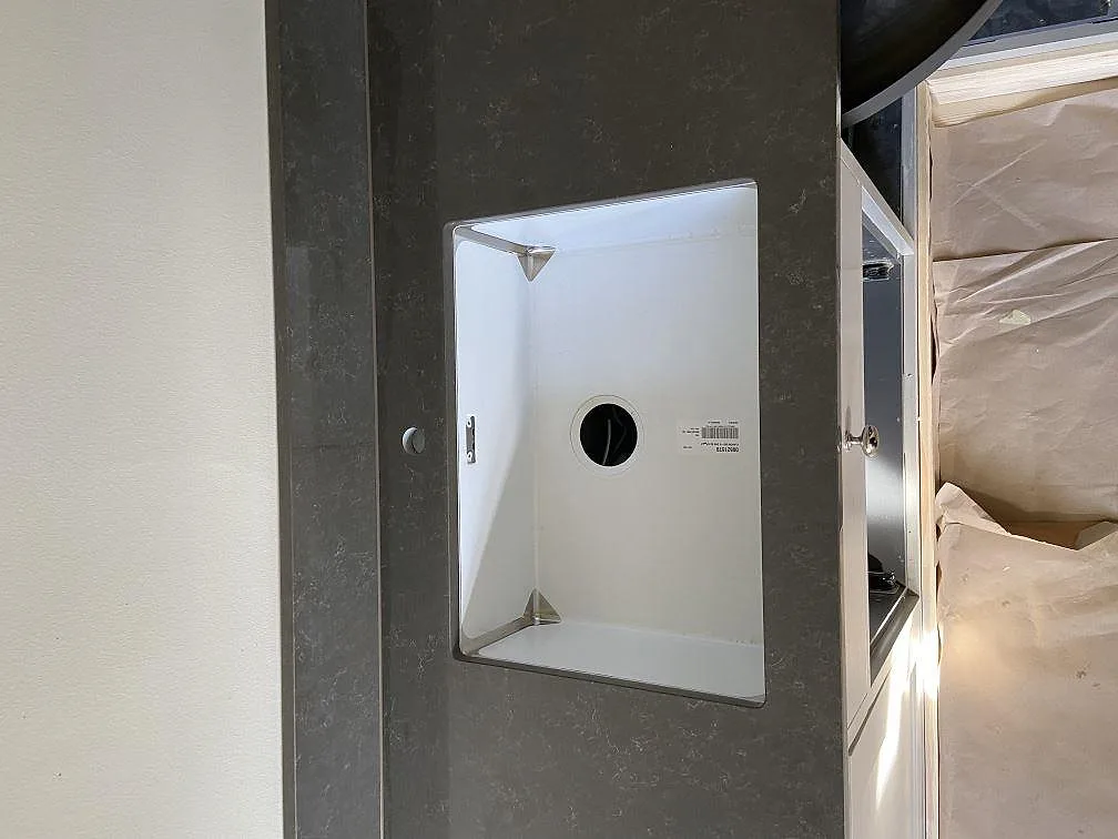 Underlimmad diskho med separat borrade kranhål i grå Technistone Noble Pietra Grey bänkskiva i ett kök i Göteborg.