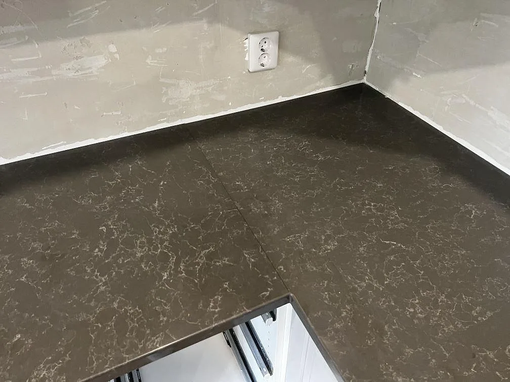 Detalj av skarv, ådring och hällurtag i polerad Technistone Noble Pietra Grey komposit i Hästveda.
