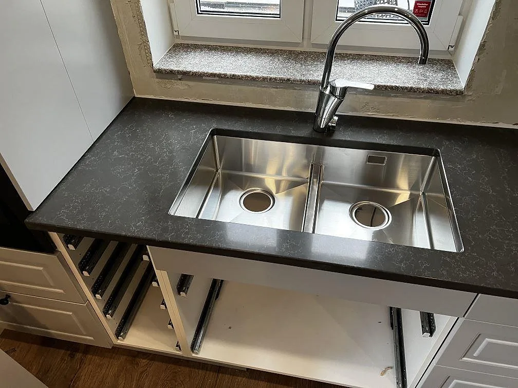 Rostfri diskho infälld i köksbänkskiva av Technistone Noble Pietra Grey, polerad komposit, i Hästveda.