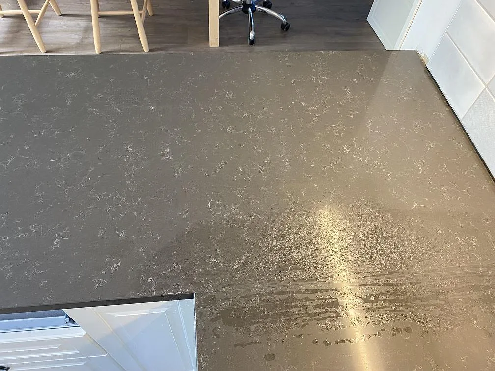 Närbild av den grå polerade kompositytan Technistone Noble Pietra Grey med fin ljus ådring i ett kök i Kungsbacka.