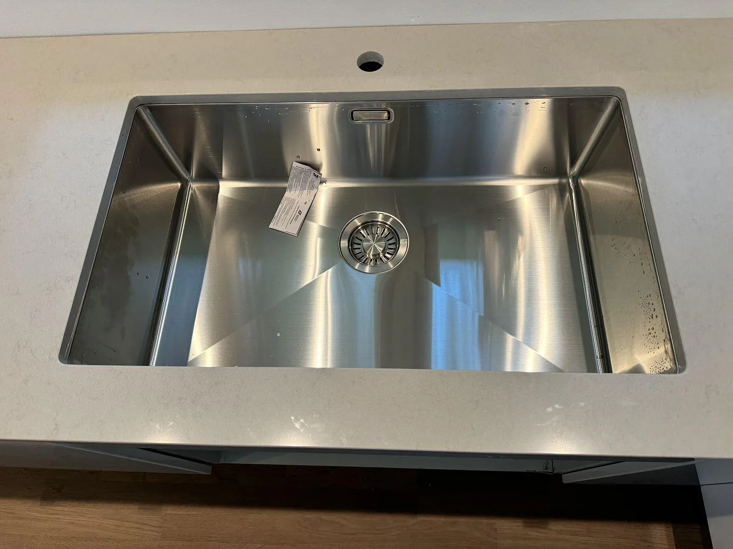 Rostfri diskho monterad i köksbänkskiva av polerad Technistone Noble Portland Grey komposit i Räng.