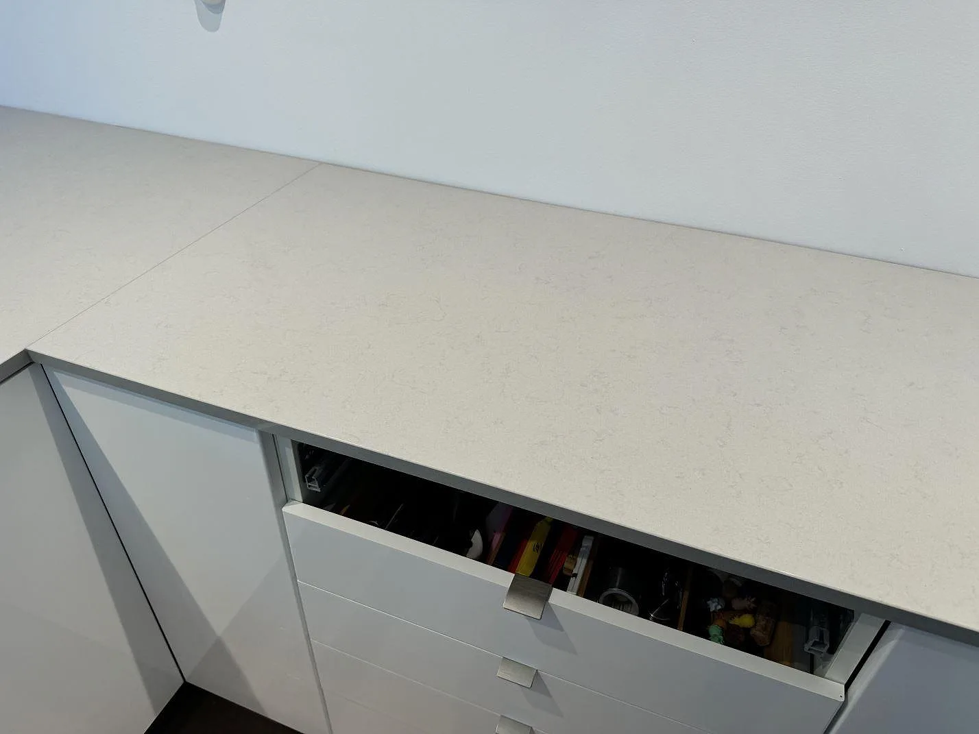 Rak arbetsyta i polerad Technistone Noble Portland Grey komposit över vita kökslådor i Räng.