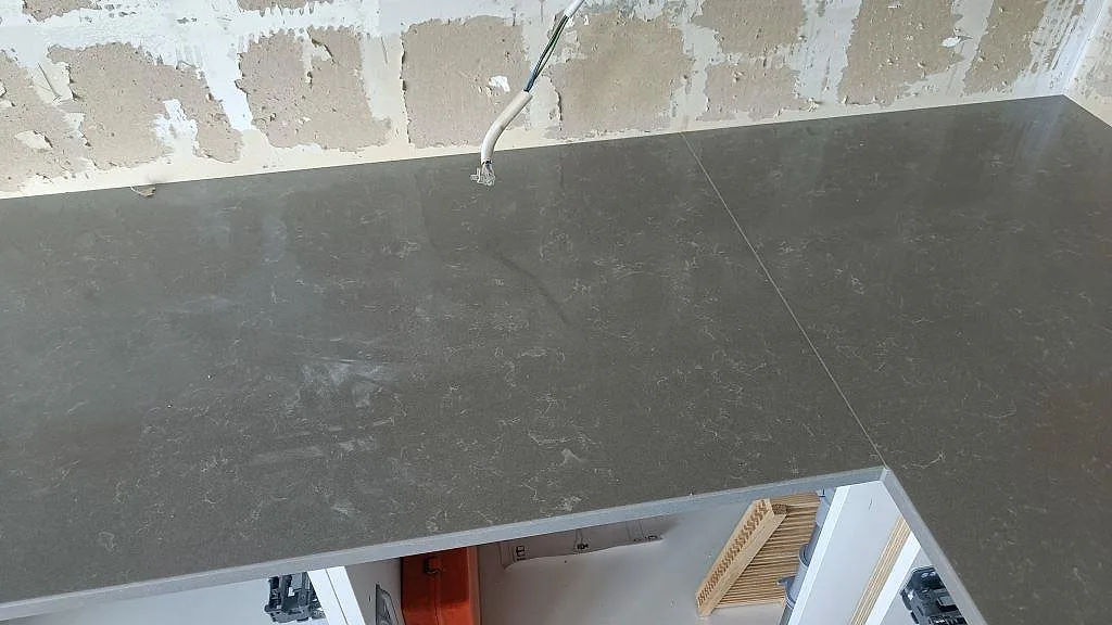 Grå köksbänkskiva i polerad Technistone Noble Pro Cloud komposit med förberett blandaruttag i Västra Frölunda.