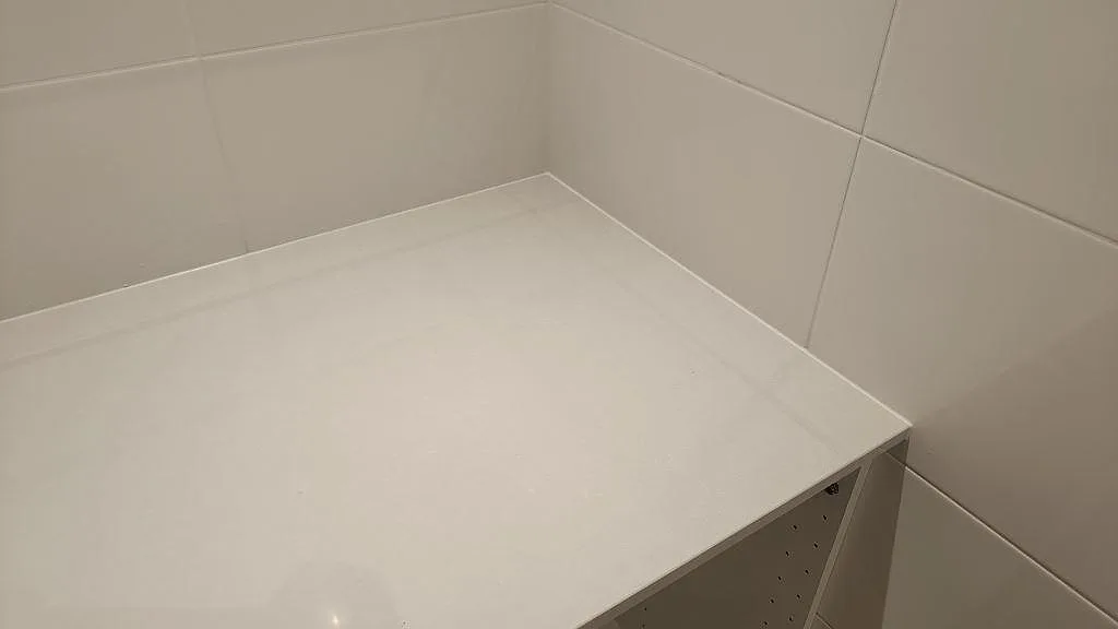 Vit bänkskiva i Technistone Noble Pro Frost mot kaklat hörn, polerad kvartskomposit monterad i Jönköping.