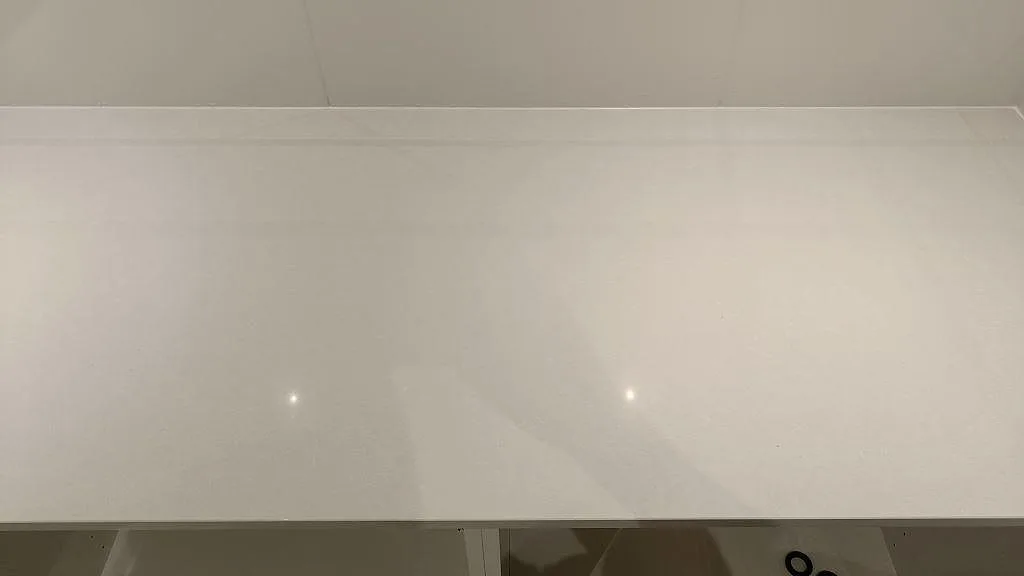 Polerad vit yta i Technistone Noble Pro Frost där spotlights speglas i stenen, kvartskomposit i ett grovkök i Jönköping.