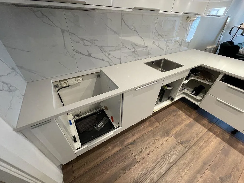 Närbild av polerad Technistone Noble Pro Frost komposit som köksbänkskiva med rostfri diskho och förberett hälluttag i Sollentuna.