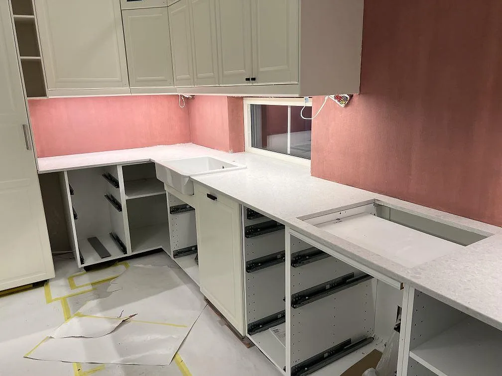 Köksbänkskiva i Technistone Noble Quartzite, 20 mm Matt, med diskho och hällöppning längs väggbänken i ett kök i Brottby.