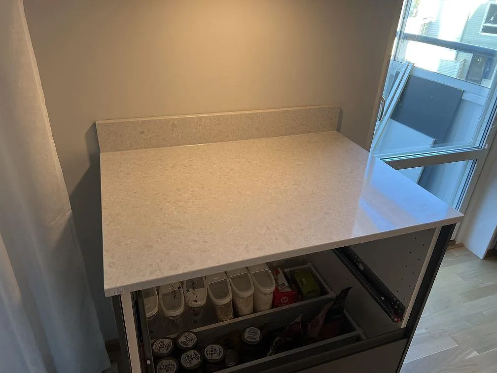 Närbild på polerad Technistone Noble Quartzite som bänkskiva med uppvikt stänkkant och ljus mönstring i Gustavsberg.