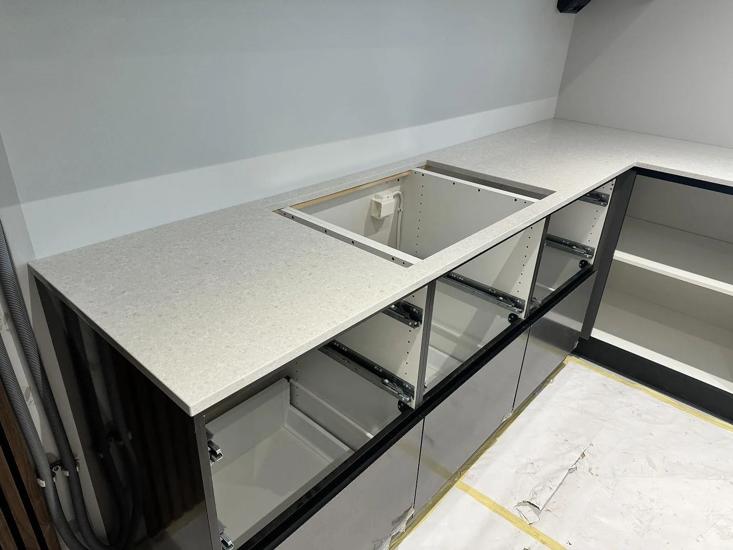 Köksbänkskiva i polerad Technistone Noble Quartzite i Malmö med ljus kvartskomposit, hällurtag och uppvikt stänkkant mot väggen.