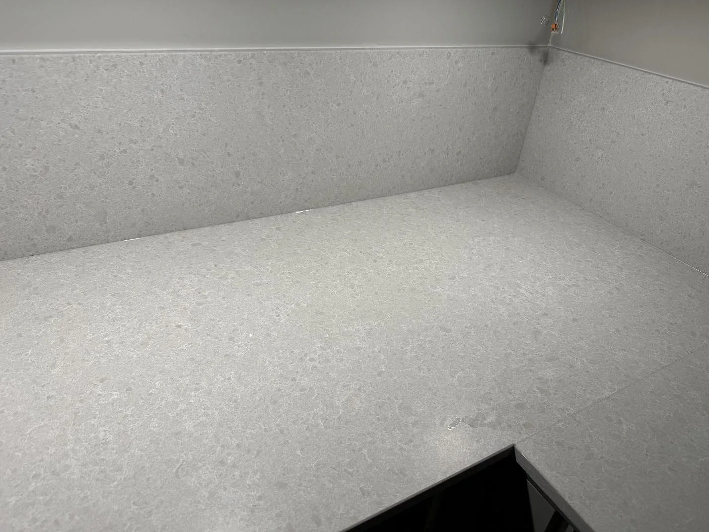 Arbetsyta och stänkskydd i Technistone Noble Quartzite, ljusgrå kvartskomposit med blandad matt och polerad finish, i ett kök i Malmö.
