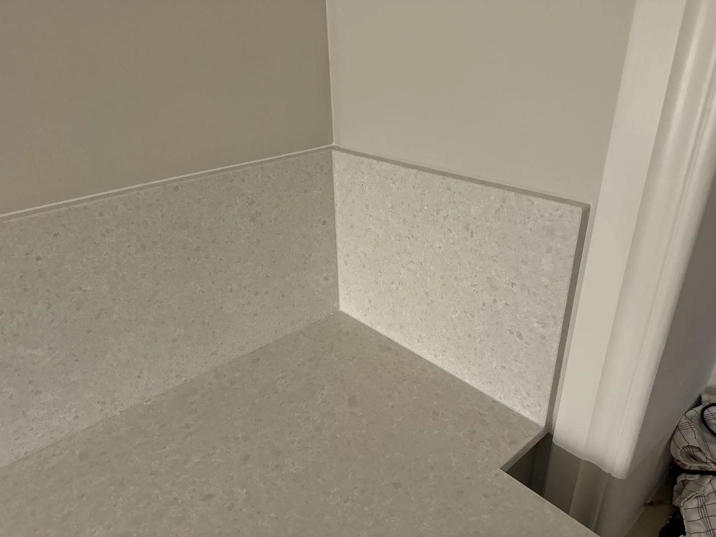 Hörn med köksbänkskiva och stänkskydd i Technistone Noble Quartzite, kvartskomposit med blandad matt och polerad finish, i Malmö.