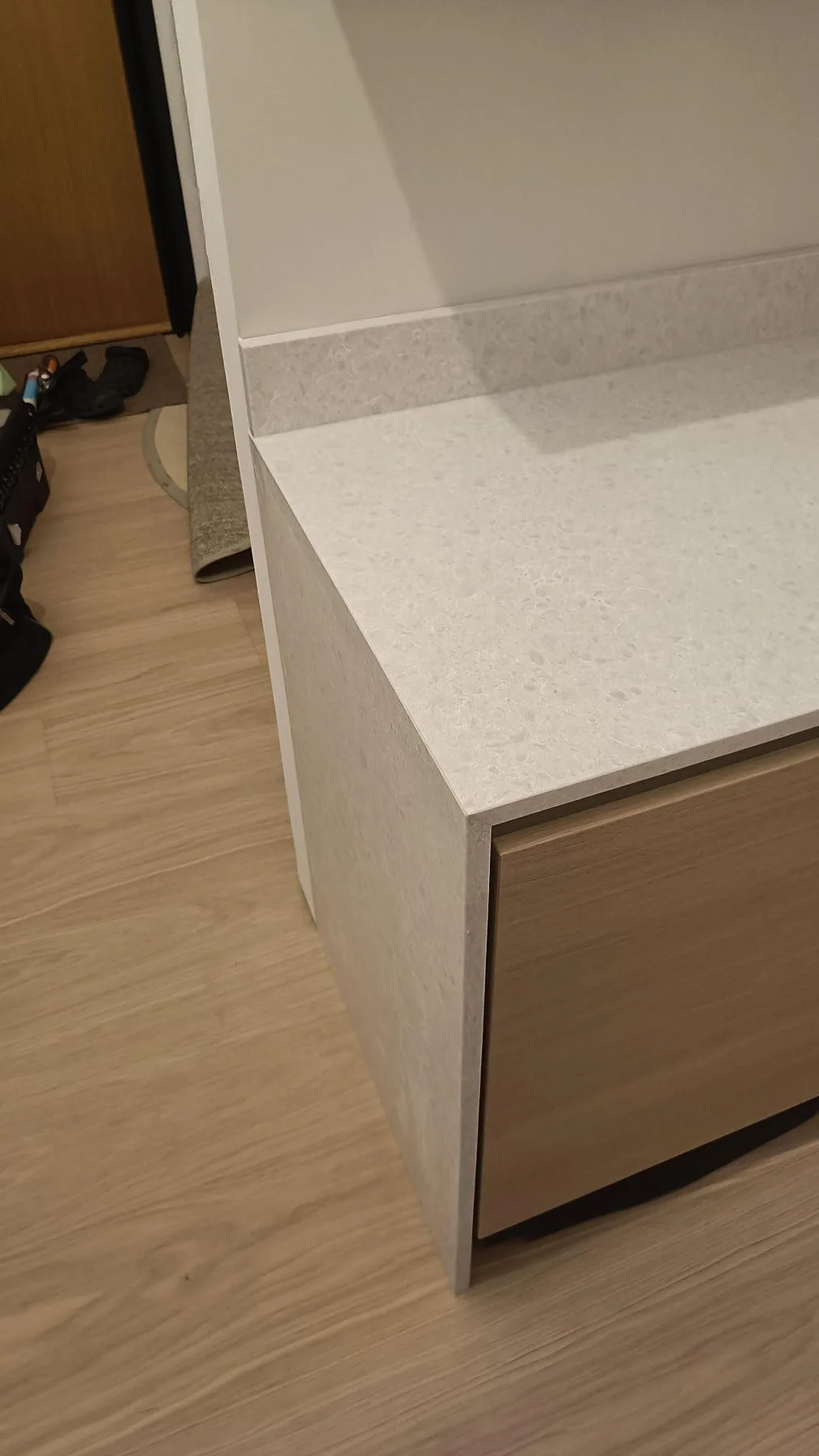 Detalj av gavelklädd bänkskiva i matt Technistone Noble Quartzite mot träinredning i Malmö.