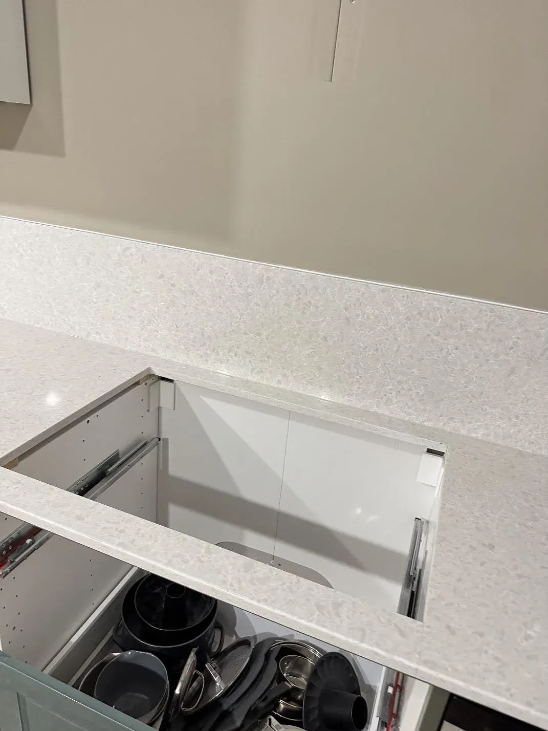 Detalj av polerad Technistone Noble Quartzite bänkskiva med låg stänkkant och rektangulärt urtag under köksmontering i Staffanstorp.