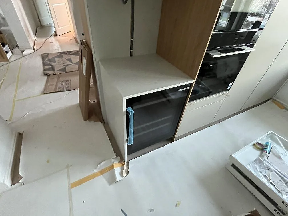 Sidovy av matt Technistone Noble Quartzite som bänkyta vid högskåp och vitvaror i ett kök under montering i Upplands Väsby.