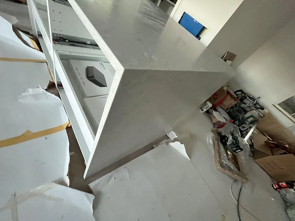Toppvy av köksö i matt Technistone Noble Quartzite, ljus kvartskomposit med neddragen sida under montering i Upplands Väsby.