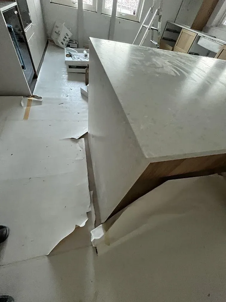 Närbild på köksö i matt Technistone Noble Quartzite, ljus kvartskomposit med neddragen stensida i Upplands Väsby.