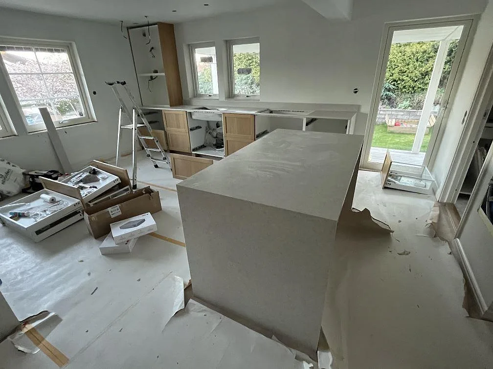 Kök i Upplands Väsby med matt Technistone Noble Quartzite, stor köksö med neddragna sidor och väggbänk i samma kvartskomposit.