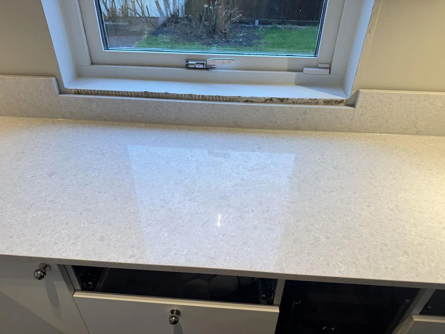 Närbild av den polerade Technistone Noble Quartzite-skivan i komposit med fönster och ljus mönstring i Västra Frölunda.