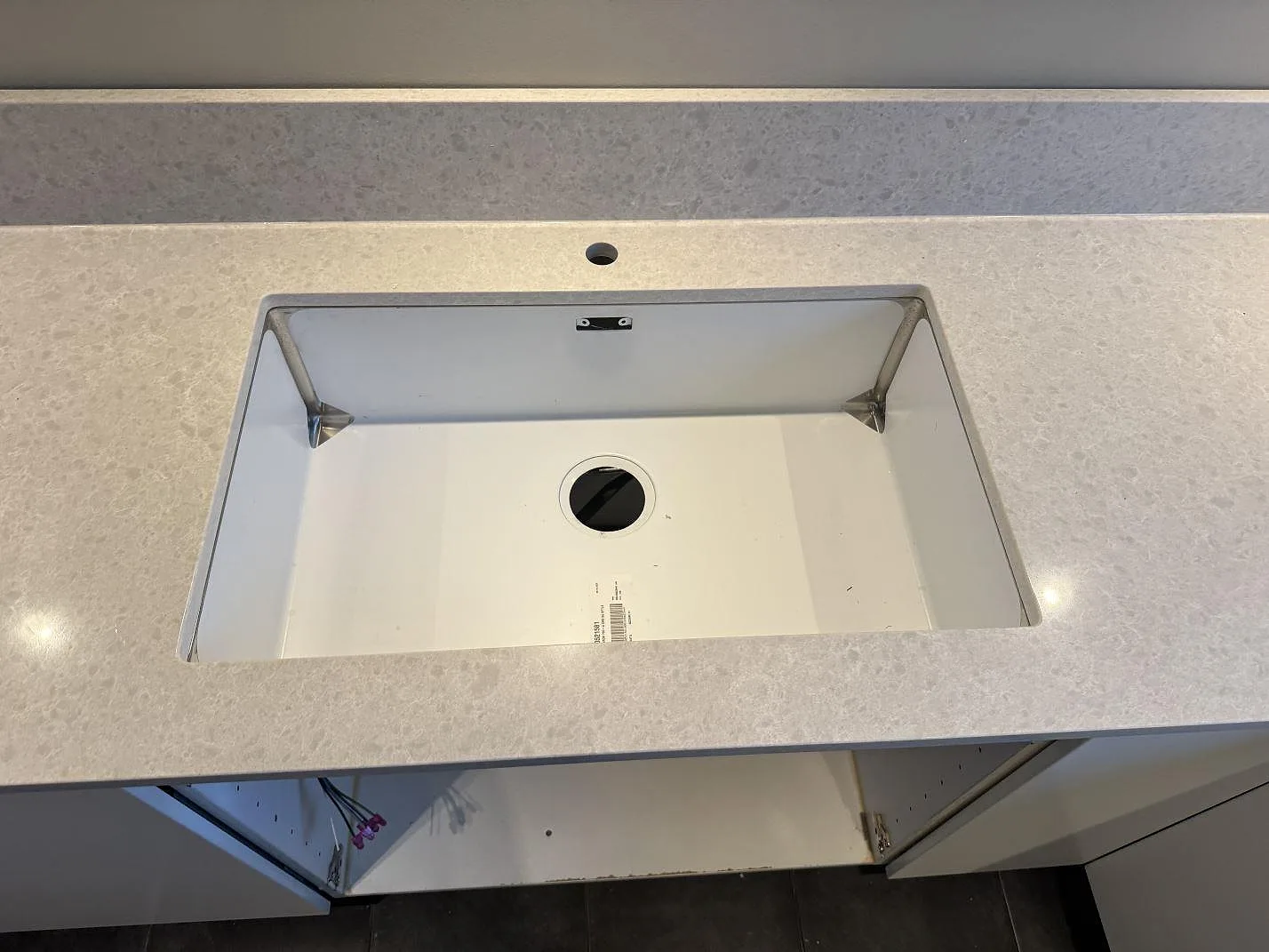Detalj av diskhozon i polerad Technistone Noble Quartzite komposit med stänkkant bakom i Västra Frölunda.