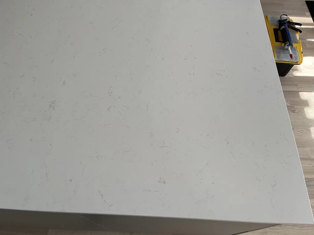 Vit Technistone Noble Supreme White köksbänkskiva med diskret grå ådring sedd ovanifrån i ett kök i Beddingestrand.