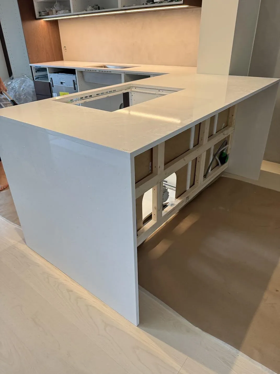Detalj av Technistone Noble Supreme White i polerad vit komposit med öppning och uppbyggda köksstommar i Karlshamn.