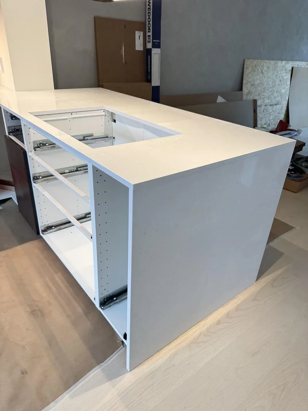 Vit polerad kompositbänkskiva i Technistone Noble Supreme White över köksstommar, fotograferad under montering i Karlshamn.