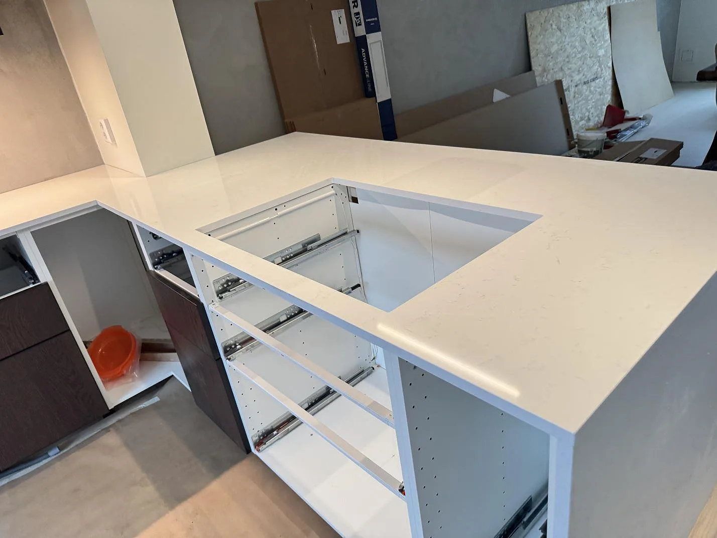 Polerad köksbänkskiva i Technistone Noble Supreme White med stor rektangulär öppning och öppna stommar i ett kök i Karlshamn.