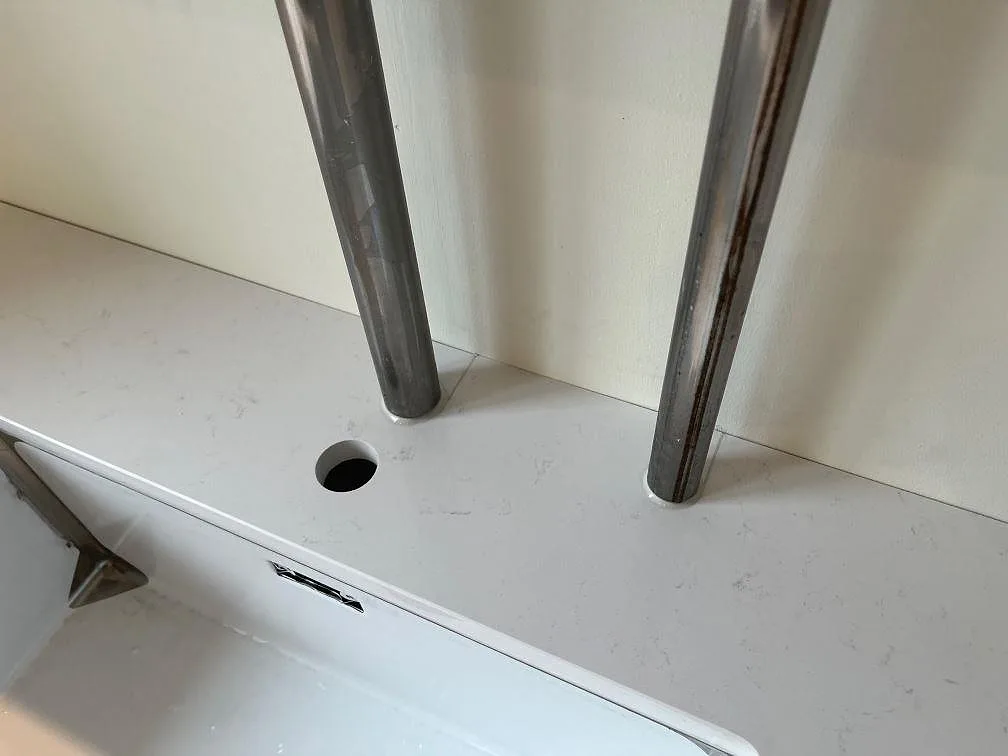 Närbild på polerad Technistone Noble Supreme White med rörgenomföringar och diskho i ett kök i København Ø.
