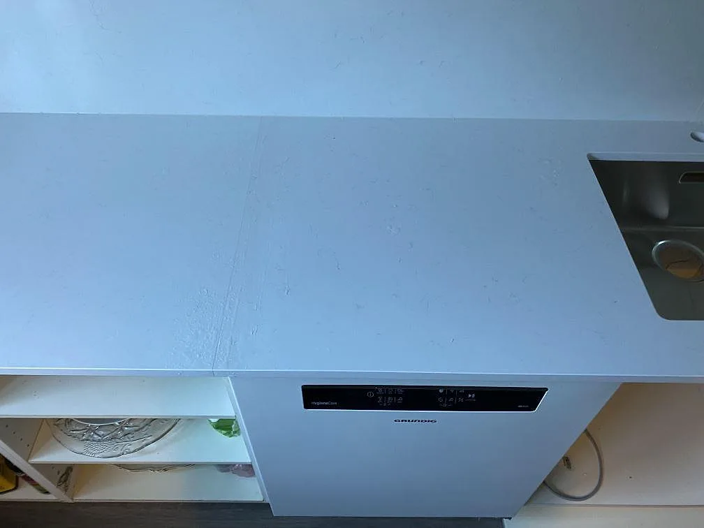 Topvy över polerad Technistone Noble Supreme White vid diskzon, med rostfri diskho och rak framkant i Malmö.