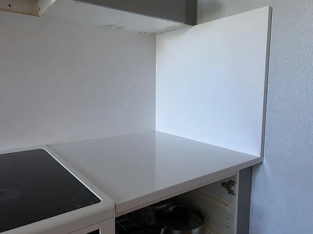 Höger avslutning av köksbänkskiva i Technistone Noble Supreme White med stående sidostycke och polerad yta i Malmö.