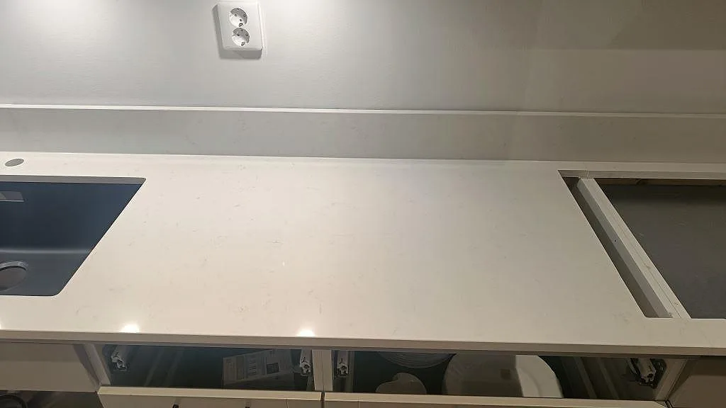 Vit Noble Supreme White köksbänkskiva med underlimmad diskho och utskuret hällurtag i ett kök i Skegrie.
