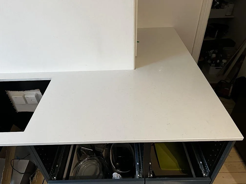 Polerad Technistone Noble Supreme White som köksbänkskiva på grå stommar med synlig ådring och hällöppning i Trelleborg.