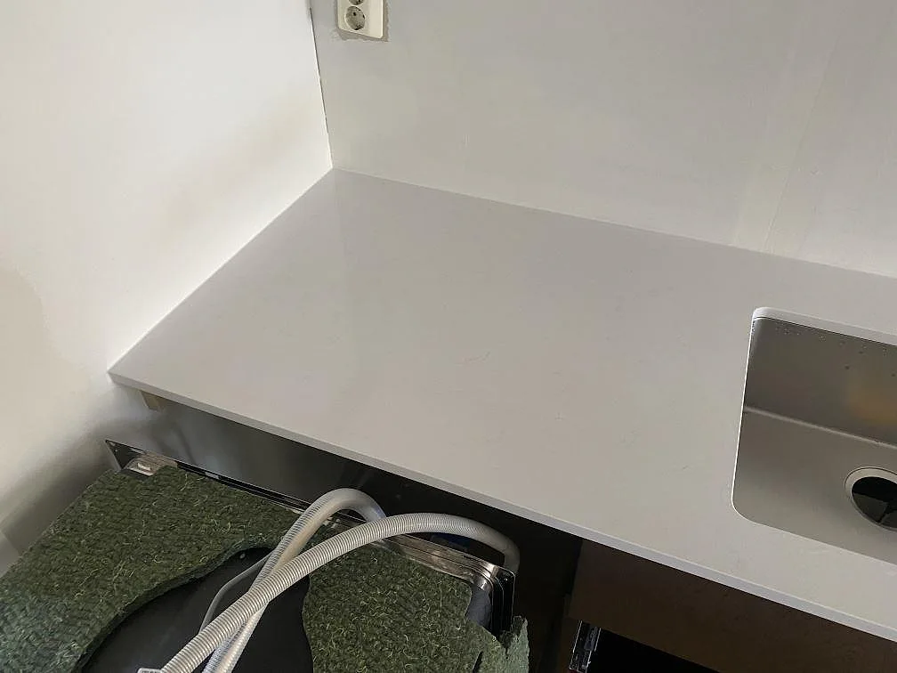 Närbild på vit köksbänkskiva i Technistone Noble Supreme White intill diskhon i Västra Frölunda.