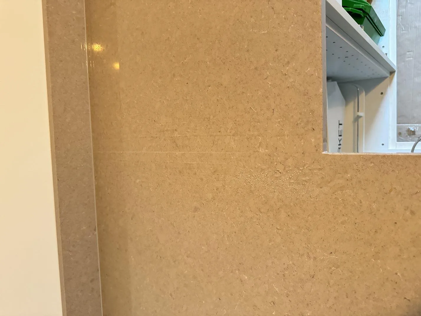 Närbild på polerad yta och kant i Technistone Noble Troya, beigegrå kvartskomposit med specklad struktur i Göteborg.