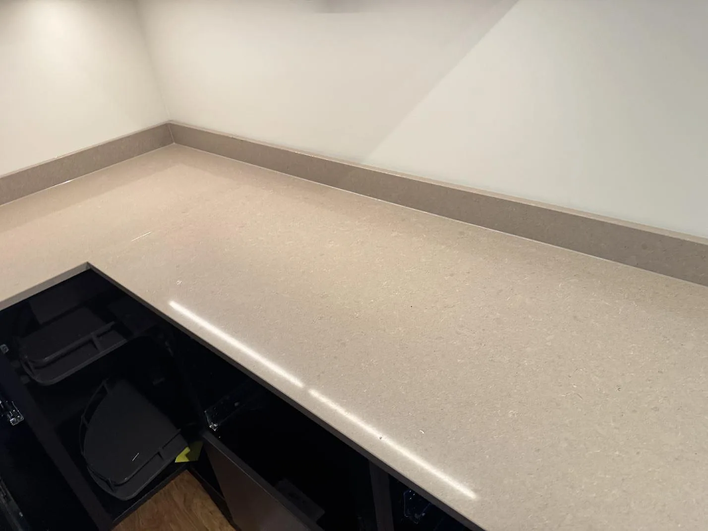 Detalj av polerad Technistone Noble Troya med ljus gråbeige stenbild och uppvikt stänkkant i ett kök i Hällingsjö.