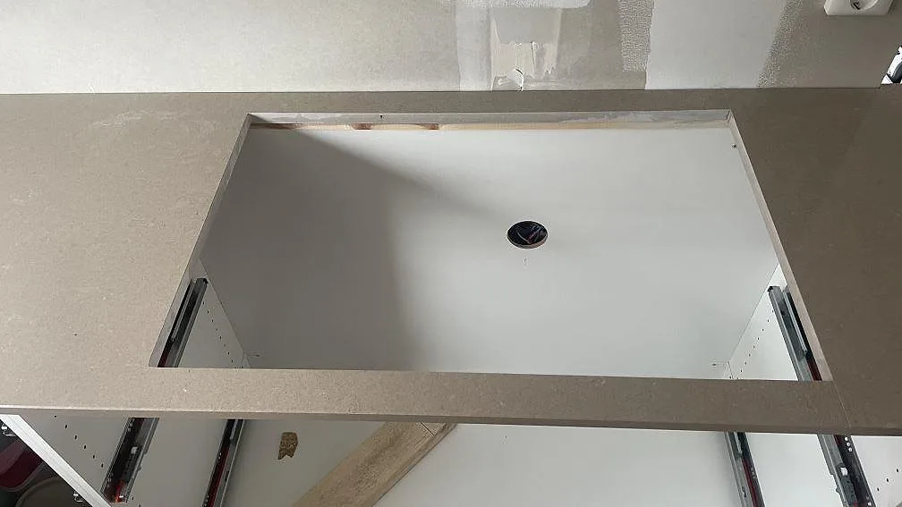 Närbild av stor utskuren öppning i polerad Technistone Noble Troya kvartskomposit på köksbänk i Höllviken.
