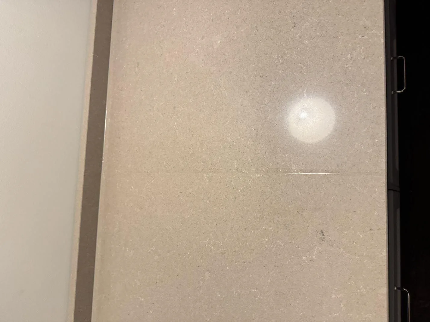 Top-down detalj av den polerade ytan i Technistone Noble Troya med ljusreflex och beige kompositmönster i Löddeköpinge.