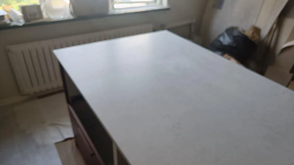 Köksö i matt Technistone Noble Villa fotograferad under montering med ljus komposityta som huvudmotiv i Göteborg.