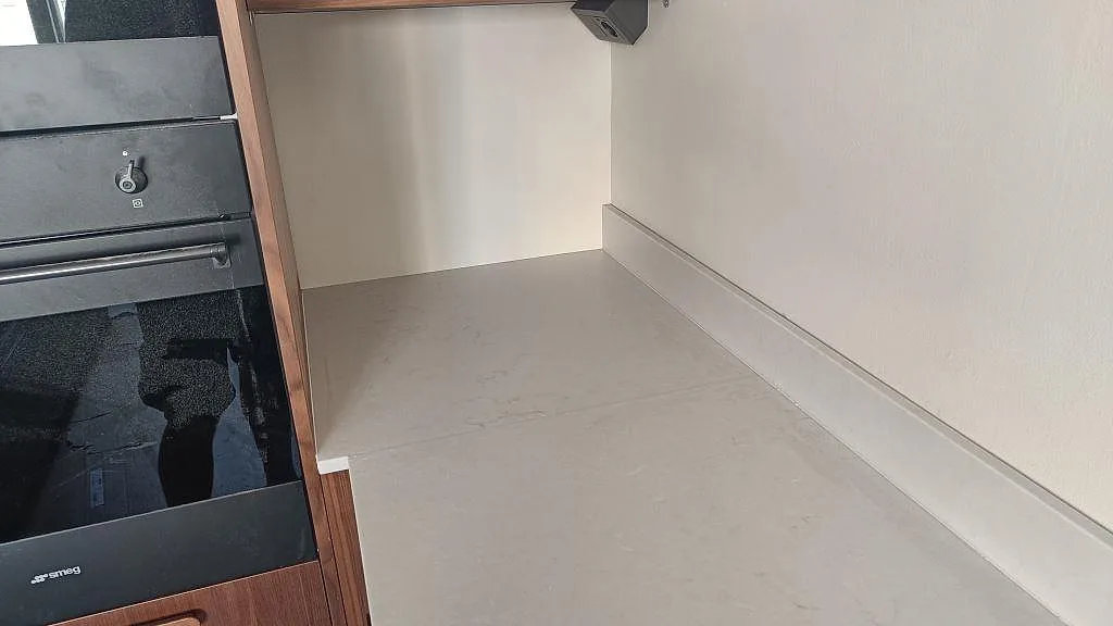 Arbetsyta i matt Technistone Noble Villa med låg stänkkant intill svart köksvitvara i Göteborg.