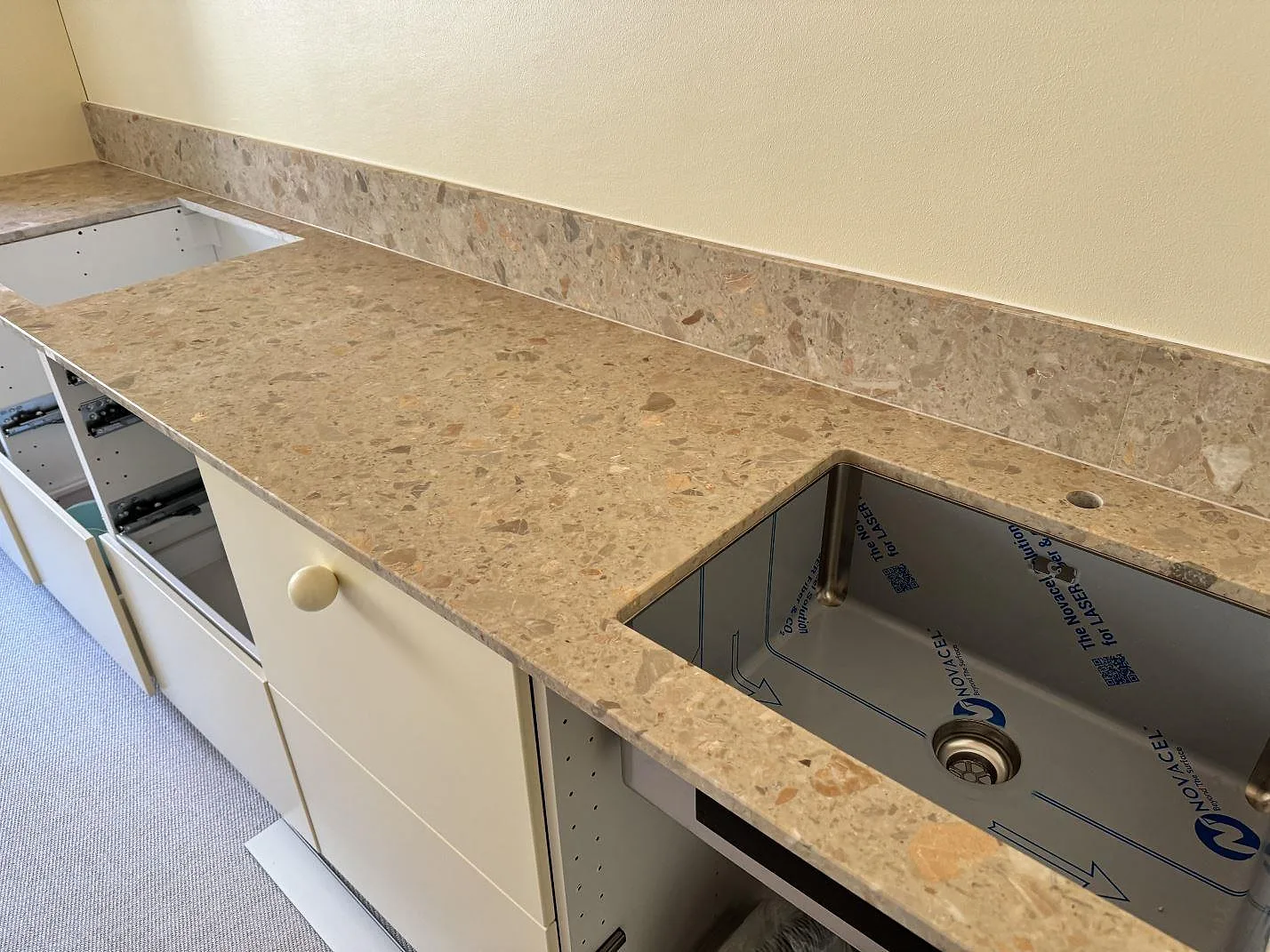 Köksbänkskiva i beige Terrazzo Breccia Oniciata, matt 20 mm terrazzo, med underlimmad rostfri diskho och låg stänkkant i ett kök i Malmö.