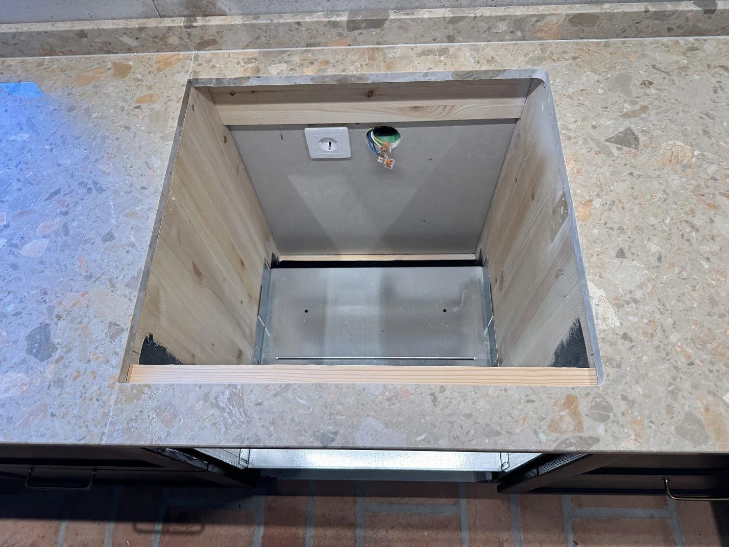 Detalj av hällöppning i en matt köksbänkskiva i Terrazzo Breccia Oniciata med uppvikt stänkkant i Tomelilla.