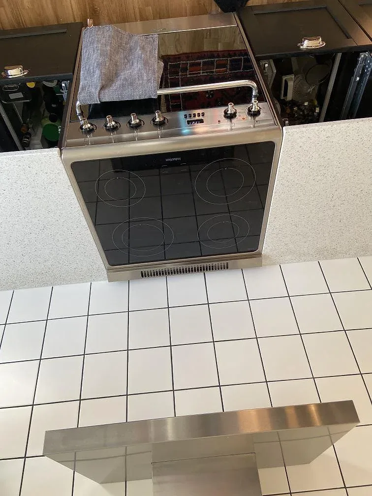 Terrazzo Carrara köksbänkskiva i vit och grå terrazzo bredvid induktionsspisen i ett kök i Lund.
